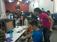 Friendly volunteers assisting young children in game development